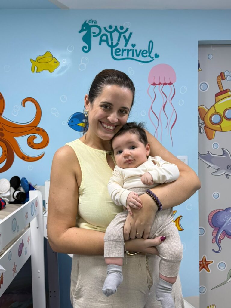Dra. Patty Terrível segurando bebê no consultório de pediatria