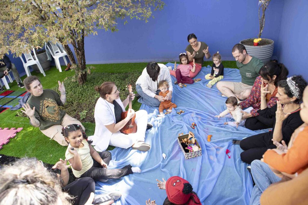 Mães e bebês nos tapetes do gramado na Brunch com Tetê 2025, evento da Clínica Mamma Gaia