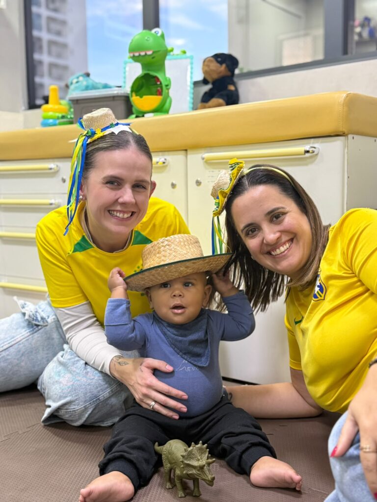 Equipe da Mamma Gaia com bebê em dia de festa na clínica