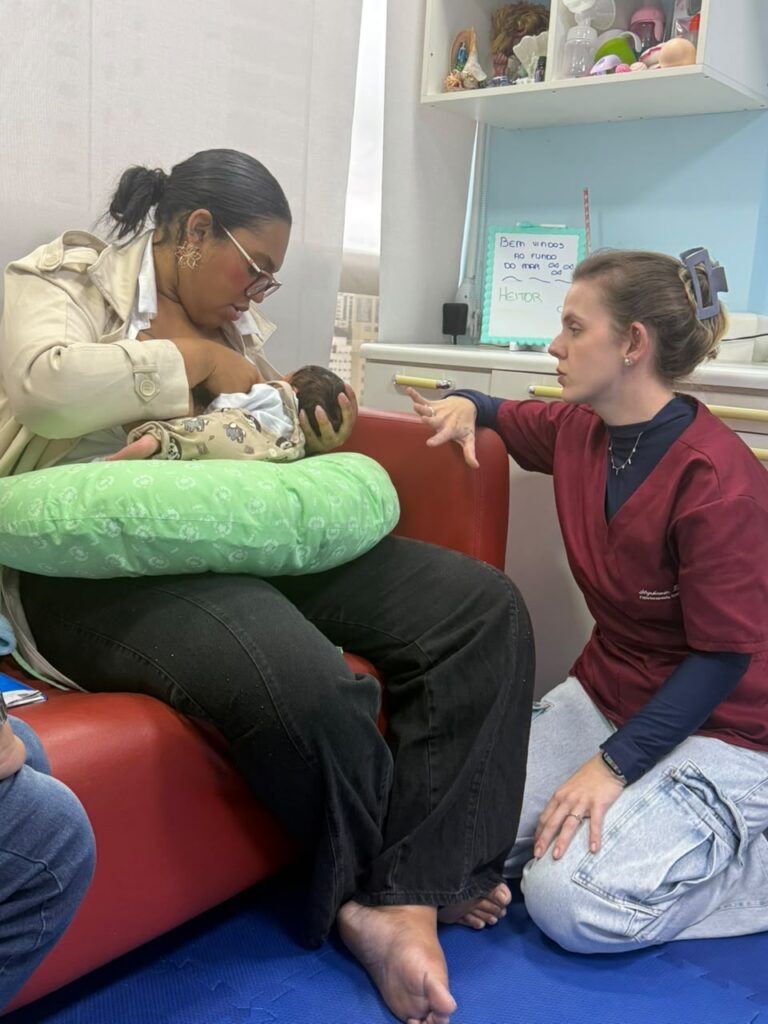 Fisioterapeuta pediátrica Stephanie orientando mãe durante consulta na Clínica Mamma Gaia