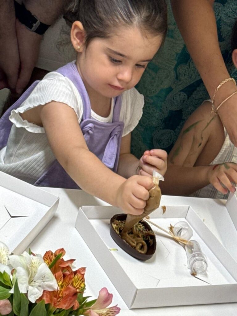 Criança decorando ovo de Páscoa na Páscoa Gaia 2026, evento da Clínica Mamma Gaia