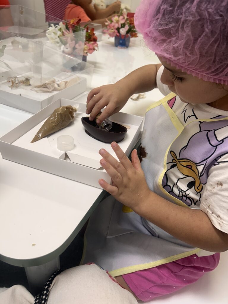 Criança montando cone de Páscoa na Páscoa Gaia 2026, evento da Clínica Mamma Gaia