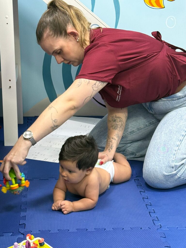 Fisioterapeuta pediátrica Stephanie Hackradt estimulando o desenvolvimento motor de um bebê